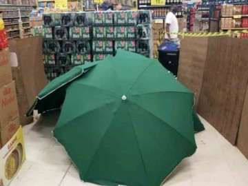 Hombre fallece en tienda y cubren el cuerpo con paraguas