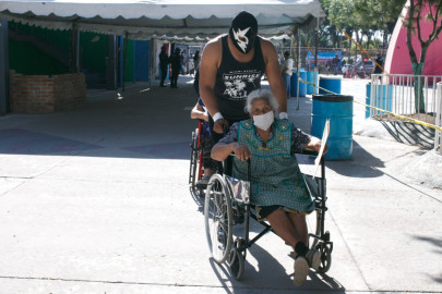 Luchadores asisten a adultos mayores que asistieron a vacunarse contra el Covid-19