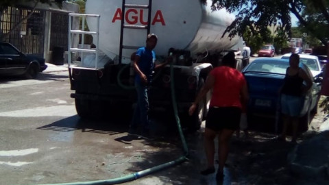 Vecinos ayudan a conductores de pipas en la entrega de agua potable