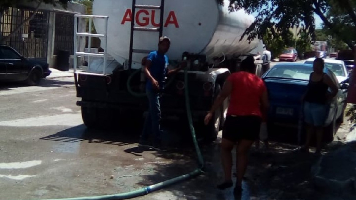 Vecinos ayudan a conductores de pipas en la entrega de agua potable