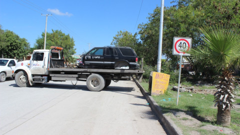 Retiran vehículos desmantelados por invadir vía pública