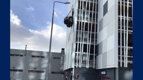 Porsche atraviesa la pared de un 'parking' y queda colgado en el aire
