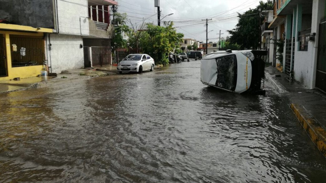 Corriente arrastra taxi en Madero