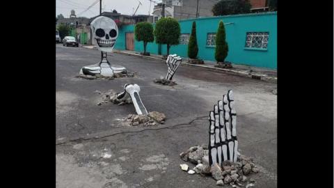 Esqueletos gigantes aprovechan baches para celebrar Día de Muertos