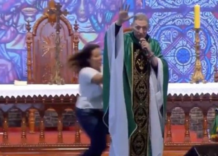 Mujer interrumpe  misa masiva y tira al padre del altar