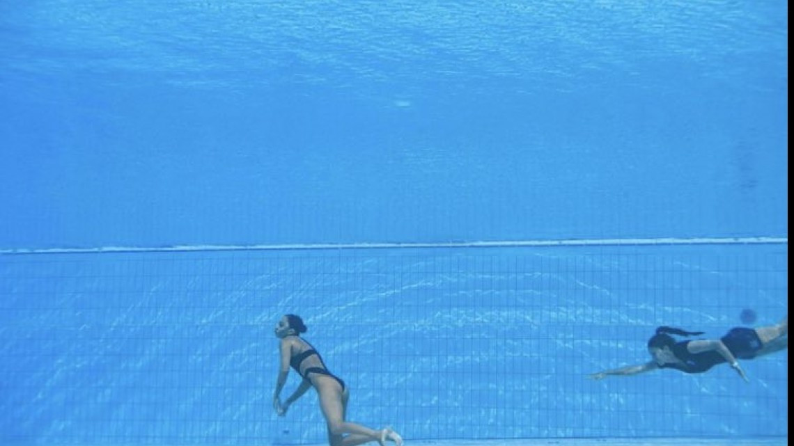 Se desmaya nadadora en plena competencia, entrenadora salta a rescatarla