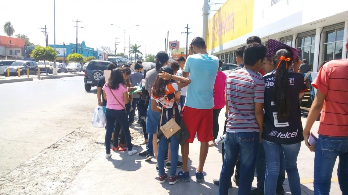 Bajo los rayos del sol y una sensación de 42 centígrados jóvenes esperan por su beca