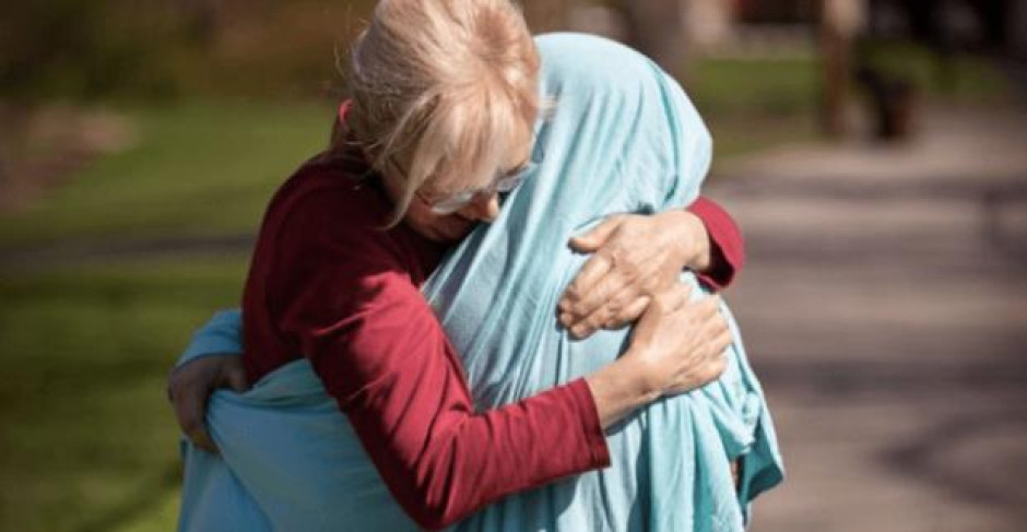 Madre cubre a su hija enfermera con una sábana para poder abrazarla