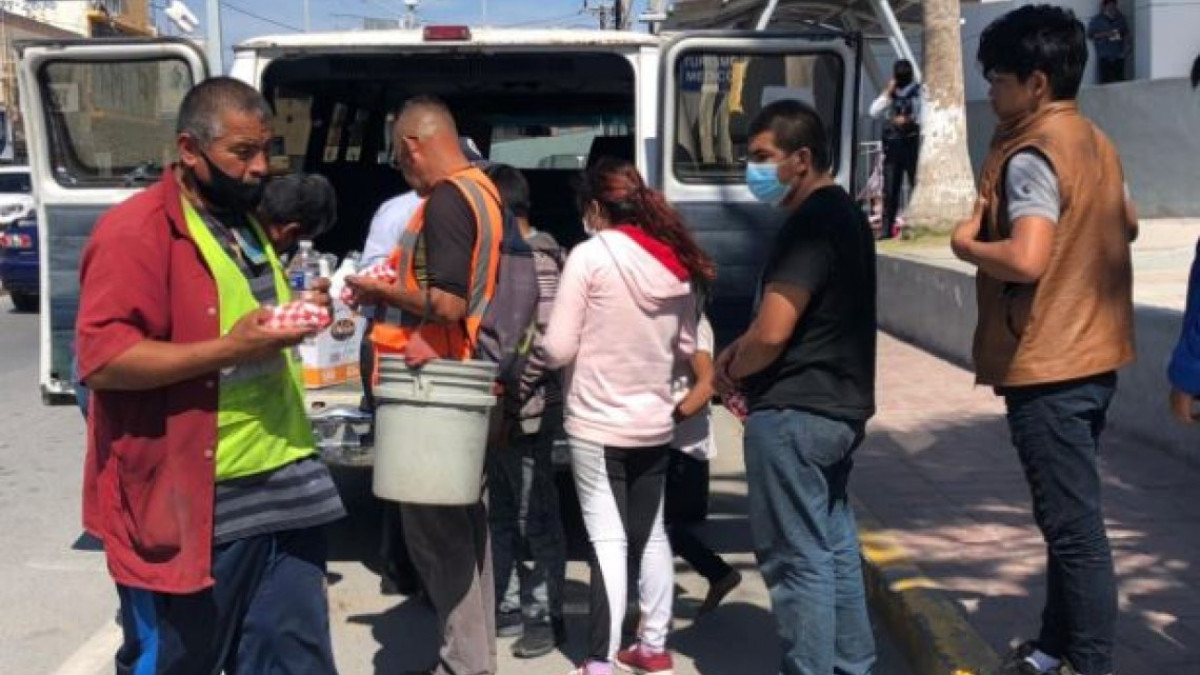 Cristianos atienden a migrantes que acampan en puente internacional