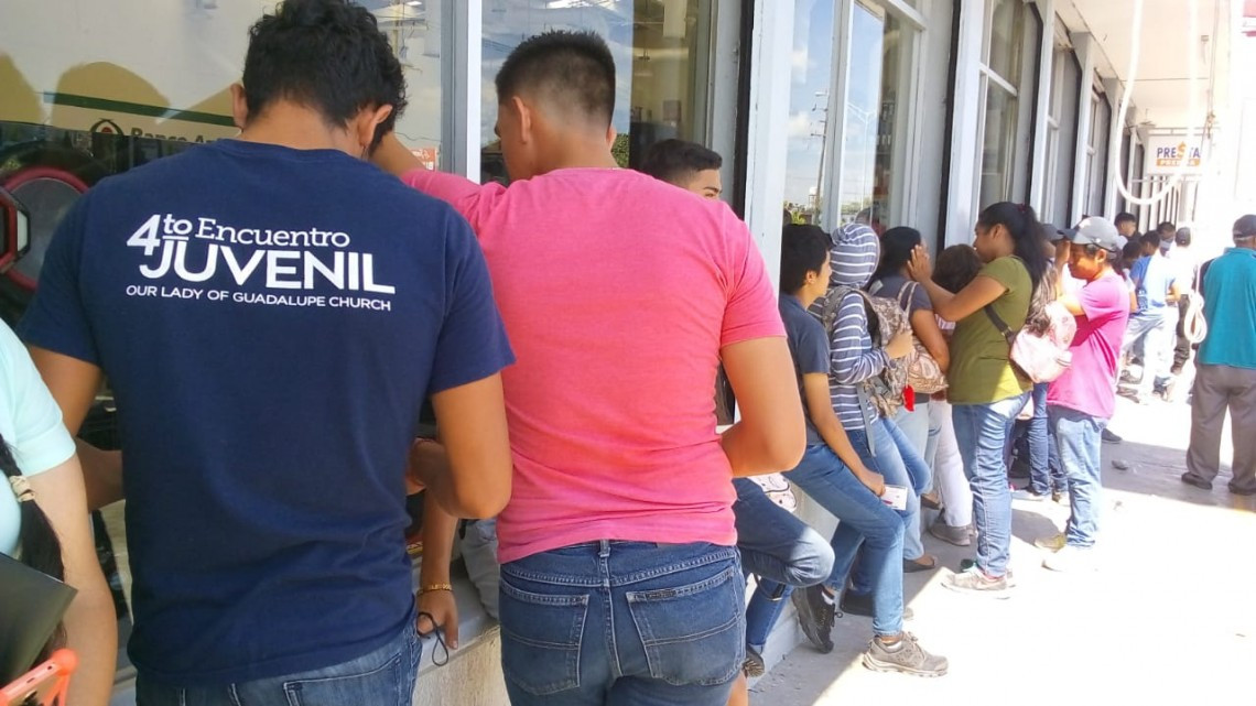 Bajo los rayos del sol y una sensación de 42 centígrados jóvenes esperan por su beca