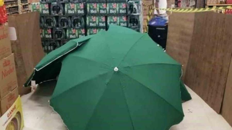 Hombre fallece en tienda y cubren el cuerpo con paraguas