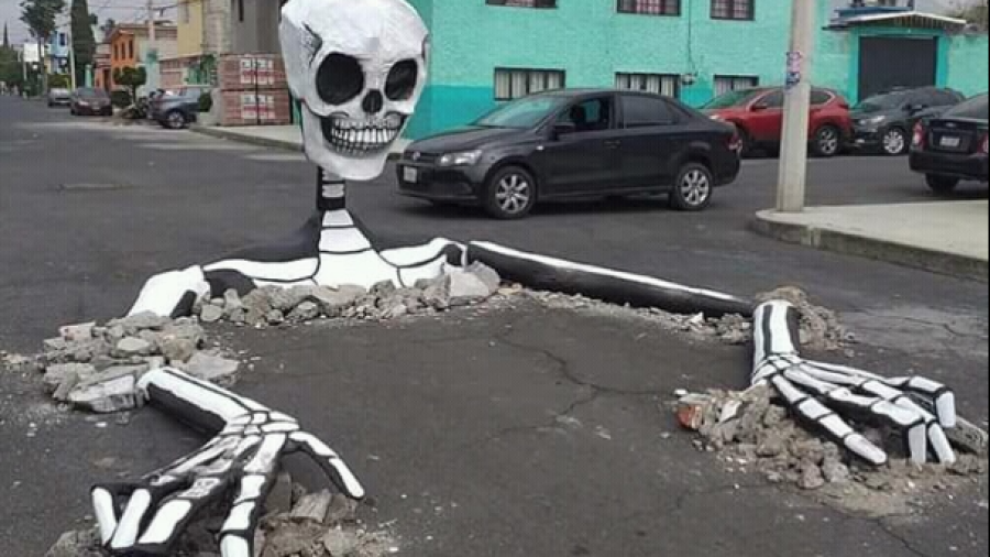 Esqueletos gigantes aprovechan baches para celebrar Día de Muertos