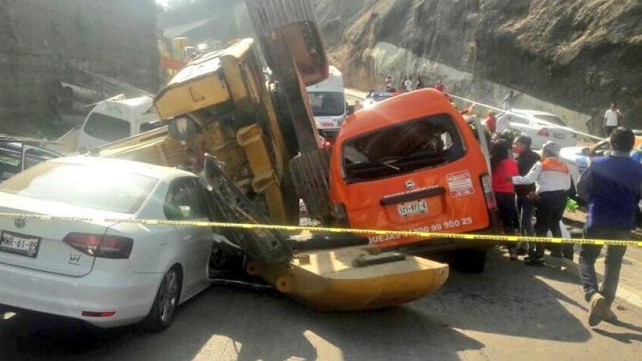 Retroexcavadora cae aplastando veh&iacute;culos